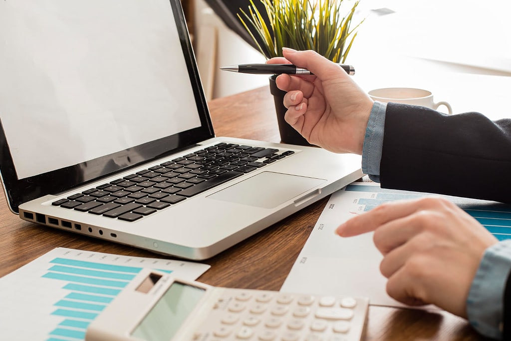 Empresário com laptop e calculadora no escritório