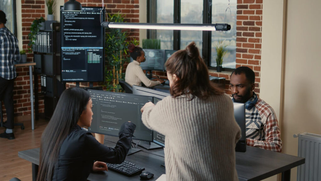 Duas mulheres trabalhando e conversando sobre algo que está sendo mostrado em um computador